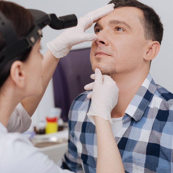doctor checking mans face
